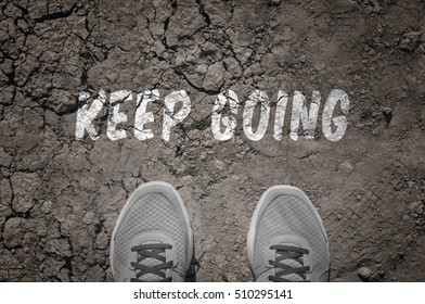 Sneakers On Dry Land With The Text: Keep Going