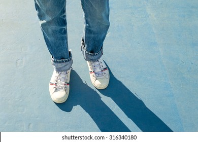 sneakers walking on blue floor.