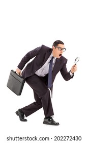 Sneaky Businessman Looking Through A Magnifying Glass Isolated On White Background