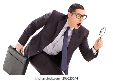 Sneaky Businessman Looking Through A Magnifying Glass Isolated Against White Background