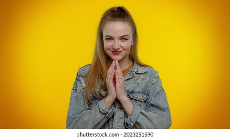 Sneaky cunning teen stylish girl with tricky face gesticulating and scheming evil plan, thinking over devious villain idea, cunning cheats, jokes and pranks. Young woman on yellow studio background