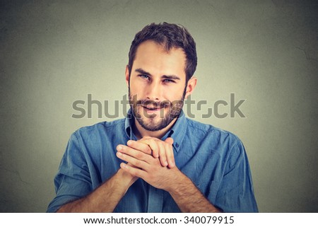 Sneaky scheming young man, worker trying to plot something, screw someone isolated on gray wall background. Negative human emotion facial expression feeling attitude