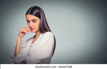 sneaky, sly, scheming young woman plotting something isolated on gray background. Negative human emotion facial expression feeling