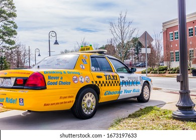 Snellville, GA/USA - March 8 2020: 
Right, Rear View Of A Police Display Vehicle To Discourage DUI/impaired Driving; With The Front Half Painted As A Patrol Car And The Rear Half Painted As A Taxi. 
