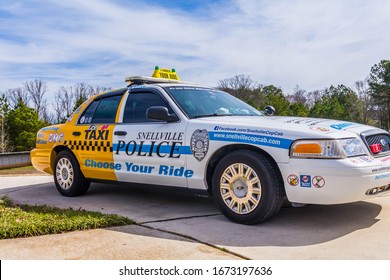 Snellville, GA/USA - March 8 2020: 
Right, Side View Of A Police Display Vehicle To Discourage DUI/impaired Driving; With The Front Half Painted As A Patrol Car And The Rear Half Painted As A Taxi. 
