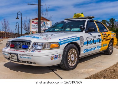 Snellville, GA/USA - March 8 2020: 
Left, Front View Of A Police Display Vehicle To Discourage DUI/impaired Driving; With The Front Half Painted As A Patrol Car And The Rear Half Painted As A Taxi. 
