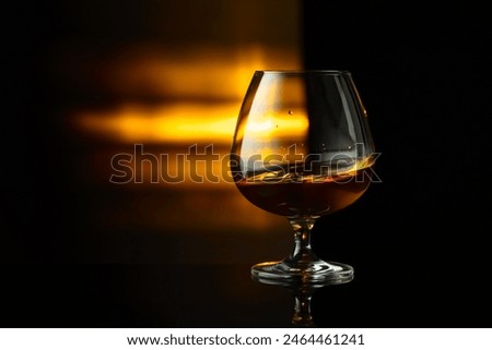 Snifter of brandy on a black background with copy space.