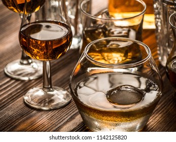 Snifters, old fashined glasses filled with whiskey on a bar top