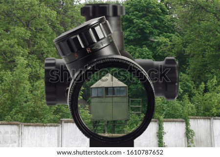 sniper look through the optical sight at a military base