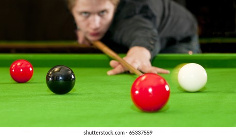 Snooker Player Placing The Cue Ball For A Shot On Black, Whilst Hitting The Red Ball (Selective Focus And Motion Blur)