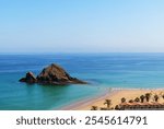 Snoopy Island in Fujairah, UAE. Aerial view of the beach with turquoise waters, a rocky island and a resort nearby