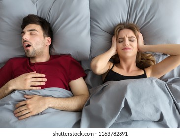 Snoring Husband. Angry Woman Covering Ears, Top View In Bed.