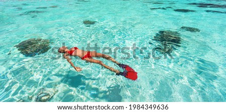 Snorkel woman swimming in the turquoise ocean sea relaxing floating on luxury travel vacation above underwater coral reefs. Water sport diving active lifestyle banner.