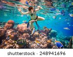 Snorkeler diving along the brain coral. Maldives Indian Ocean coral reef.