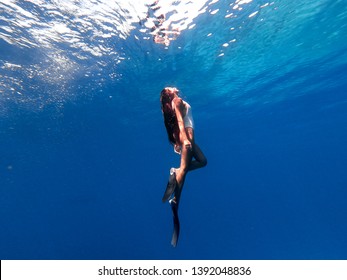Snorkeling woman exploring beautiful ocean sealife. Water sport outdoor activities. Swimming and snorkeling on summer holidays. Under and above water photography.