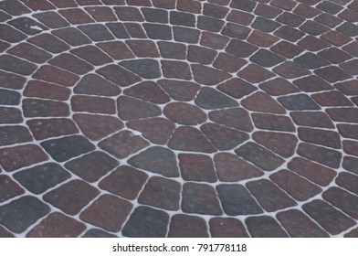 Snow Adds To Circular Design Pattern Of Sidewalk Made Of Gray And Maroon Concrete Brick Pavers