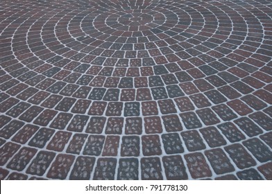 Snow Adds To Circular Design Pattern Of Sidewalk Made Of Gray And Maroon Concrete Brick Pavers