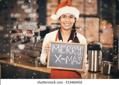 Snow against pretty waitress with a chalkboard merry x-mas - Powered by Shutterstock