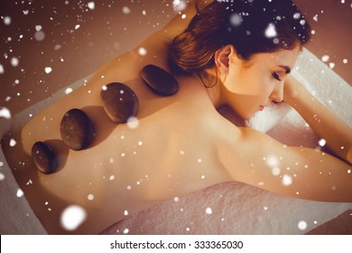 Snow Against Young Woman Getting A Hot Stone Massage