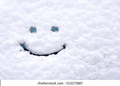 Snow Background. Texture Of Wet Snow With A Cheerful Smiley Symbol Pattern In The Winter Window Of The Car Outdoors Close-up. Smile In The Snow, Happy Cheerful Image.