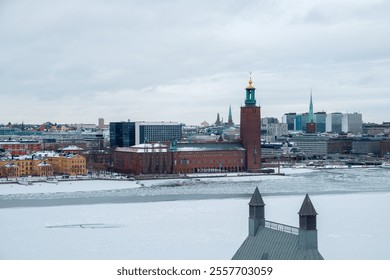 Snow blankets the city of Stockholm as the skyline reveals historical buildings and modern architecture. The icy waterfront reflects the chilly winter atmosphere typical of this Swedish capital. - Powered by Shutterstock