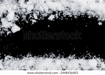 Snow border on a black background. Crunchy natural snow frame with space for copy.