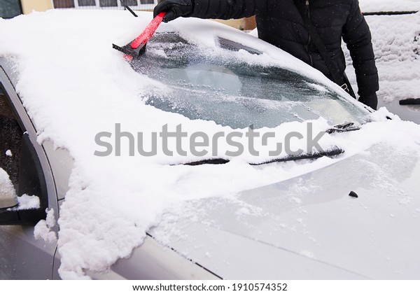 A snow brush\
slides down a car windshield, removing fresh, wet snow that\
accumulated during a recent\
snowfall.
