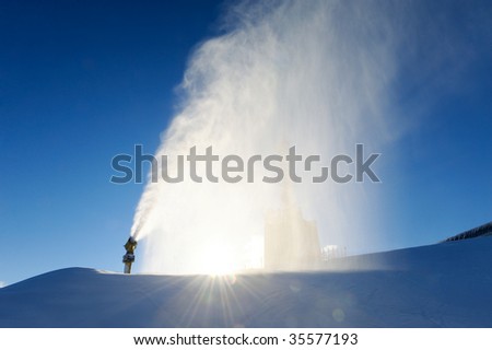 snow cannon making powder snow with blue sky in the background