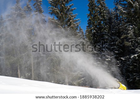 Snow cannons make snow surface. Snow cover for the winter season at the ski resort. Snow making machine
