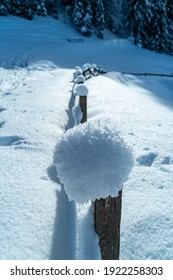 Snow Cap With Ice Crystals On A Fence Post, With A View Of A Number Of Fence Posts Along The Way. Special Winter Wonderland In Bregenz Forest. Snowy Field On The Alps