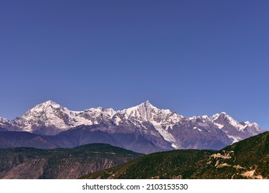 snow capped meili mountain range under blue sky in china's yunnan province
