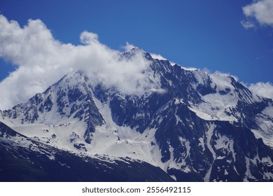 Snow capped mountain with clouds passing over 