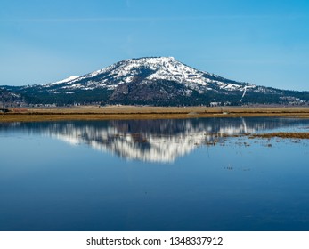 Snow capped mountain with a nice reflection in a smooth lake.