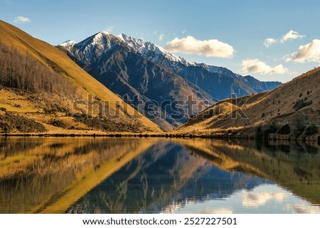 Snow capped mountain peak reflected in the calm surface of alpine Lake Kirkpatrick near Queenstown NZ