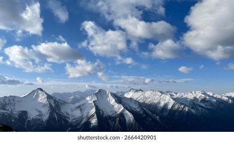 Snow Capped Mountain Range Under Blue Sky with White Clouds Scenery