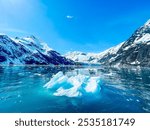 Snow capped mountains of Alaska with huge glaciers and ice chunk in the ocean