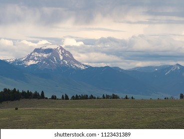 Snow Capped Rugged Mountain In The Tobacco Root Range That Is Part Of The Rocky Mountains. Overcast Skies Are Overhead And Prairie Is In The Foreground.