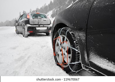 Snow chains on the wheels of the car. Snowy weather