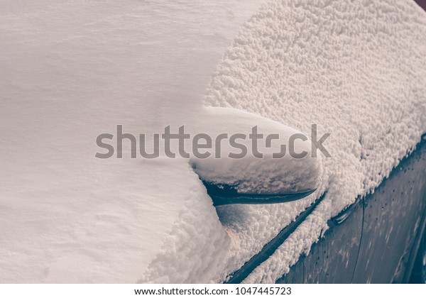 Snow cleaning from the car in bad weather\
and snowstorm, snowy frosty winter\
weather