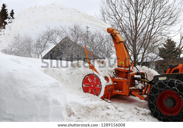 Snow\
clearing work with a large snow blower in\
winter\
