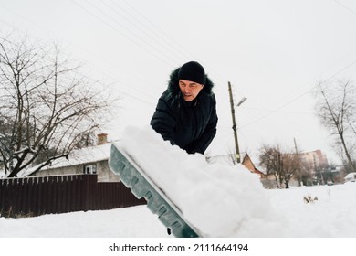 Snow Collapse. Senior Man Cleaning Snow At Winter Weather With A Shovel On A Yard During The Cold Day. Winter Trouble Concept