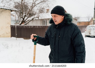 Snow Collapse. Senior Man Cleaning Snow At Winter Weather With A Shovel On A Yard During The Cold Day. Winter Trouble Concept