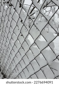 snow at countryside - chain-link fence covered by white snow - Shutterstock ID 2276694091