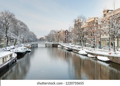 Snow covered Amsterdam canal in cold winter. Amsterdam is the capital of the Netherlands.