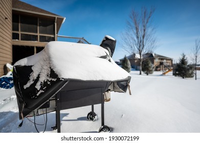 Snow Covered BBQ Smoker Grill In The Backyard With Winter Background