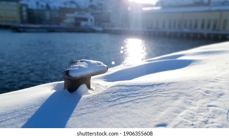 Snow Covered Bollard On A Pier On A Sunny Winter Day