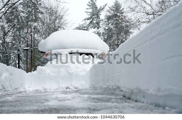 snow covered car after blizzard with snow removed\
driveway by snow blower