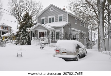 Snow Covered Car and Gray Suburban Home After Winter Snow Storm