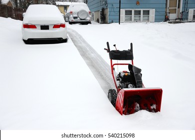 Snow Covered Car On The Driveway After Blizzard With Snow Blower