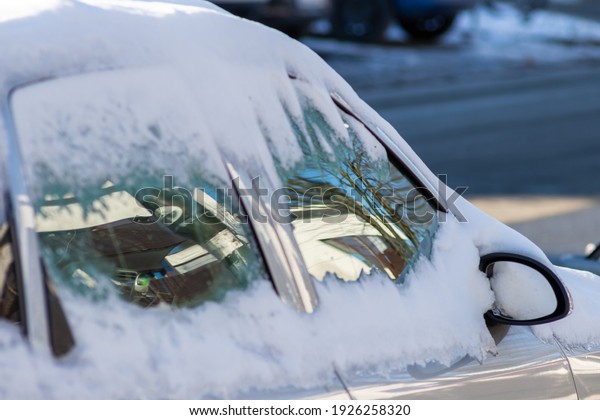 Snow covered car windows after blizzard and\
snowstorm show icy windows and danger due to extreme weather\
phenomenon with snowdrift and slippery roads and icy streets in\
cold winter with insurance\
need
